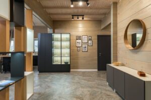 Tavelvägg med små inramade motiv i en träpanelad hall